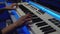 Close-up of hands of songwriter playing keyboard synthesizer, creating new song in music studio