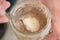 Close up of hands with a spoon grabbing part of sourdough starter