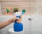 close up of hands spray using a bottle sprayer when cleaning the glass