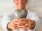 Close up of hands of teenager or man holding in his hands a metal heart smiling - love and passionate lifestyle