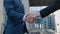 Close up of the hands of top managers in business suits, shake hands with each other, at Business center background