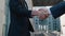 Close up of the hands of top managers in business suits, shake hands with each other, at Business center background