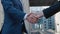 Close up of the hands of top managers in business suits, shake hands with each other, at Business center background