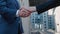 Close up of the hands of top managers in business suits, shake hands with each other, at Business center background