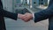 Close up of the hands of top managers in business suits, shake hands with each other, at Business center background