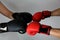 Close-up hands of two boxers in red and black boxing gloves closed for sports greeting on a light background with space for copy