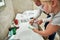 Close up of hands of two children, boy and girl holding toothbrushes, squeezing toothpaste from the tube while brushing