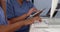 Close up hands of two female doctors working with computers