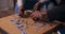 Close-up of the hands of two people of African appearance putting together puzzles. Young people choose the necessary