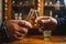 Close up on hands of two unknown men toasting with traditional serbian drink plum brandy rakija slivovitza holding glass called