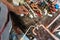 Close up on hands of unknown industrial worker plumber with central heating copper pipes welding using gas torch or blowtorch at