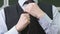 Close-up of hands of unknown schoolboy tying tie