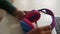 Close-up hands of unrecognizable African-American young woman holding modern colorful wireless headphones sitting at