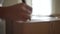 Close-up hands of unrecognizable African-American young woman writing label on cardboard box for moving out to new house