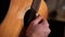 Close-up hands of unrecognizable guitarist man playing on acoustic guitar at home recording studio.