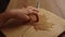 Close-up hands of unrecognizable little girl putting withered autumn maple leaf on parchment paper, smooths out to