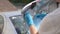 Close-up hands of unrecognizable male auto owner in rubber gloves cleaning out trunk of car. Close-up cropped shot of