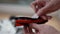 Close-up hands of unrecognizable man cleaning brush of modern robot vacuum cleaner. Close up side view of male doing