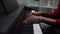 Close-up hands of unrecognizable man playing on digital piano at home recording studio.