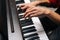 Close-up hands of unrecognizable man playing on piano at home recording studio.