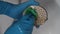 Close-up hands of unrecognizable man in rubber gloves cleaning calcified shower head in bathroom over bathtub using