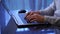 Close-up of hands of unrecognizable man typing on laptop keyboard working home