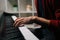 Close-up hands of unrecognizable musician man playing on synthesize gentle classical music at home.