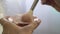 Close-up of hands of unrecognizable woman holding powder compact with brush.
