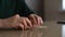 Close-up hands of unrecognizable young woman putting handwritten Christmas letter into envelope and closes it, sitting