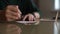 Close-up hands of unrecognizable young woman writing handwritten wishes on Christmas card sitting at table at home