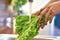 Close up of hands washing lettuce in kitchen sink before cooking, preparing a meal. Vegetarianism, healthy food, hygiene