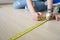 Close up hands woman engineer with yellow carpenters tape measuremeasure tape at construction site. background construction