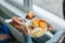 Close up of hands of woman holding a spoon and homemade granola in a plate with natural ingredients.