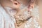 Close-up hands of woman seamstress tailor dressmaker designer wedding dress sews beads to lace on a blue background in