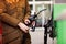 Close-up of hands of woman at self-service gas station, hold fuel nozzle and refuel the car with petrol, diesel, gas