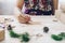 Close up of hands woman writing empty wishlist and christmas card on wooden table with xmas decoration