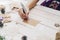 Close up of hands woman writing empty wishlist and christmas card on wooden table with xmas decoration