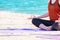 Close up hands of yoga group seated doing Hand Mudra and meditates on sand at coastline beach, Calm and relax