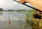 Close-up of the hands of a young Fisherman holding a fishing rod, two maggots on the hook.