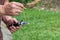 Close-up of hands young man holding refractometer for measure craft beer sugar level. Selective focus. Home brewing process