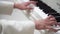 Close-up of hands of young musician in white jacket play music on the piano. Classical music, concert, performance