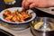 Close up hands of young woman eating shrimps in restaurant