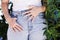 Close up of the hands of a young woman with the rainbow manicure on her jeans