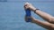 Close up of hands of young woman squeezing blue towel after swimming on the beach of Bali island. Female traveler with
