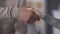 Close-up handshake of African American male hand and Caucasian tattooed female arm. Multiracial young people shaking