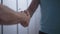 Close-up handshake of two Caucasian sportsmen in locker room. Unrecognizable confident men shaking hands in dressing