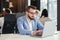 Close up handsome confident bearded office manager in business suit works with laptop at the office room.