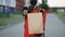 Close up handsome courier man holding paper bag with food at street outdoors worker grocery to house door to door