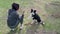 Close-up of Handsome Young Woman of Caucasian Ethnicity Training Obedience with Border Collie on the Field. Black and White Dog Gi