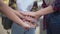 Close-up handstack of teenage Caucasian female hands outdoors. Unrecognizable group of girls stacking hands standing on